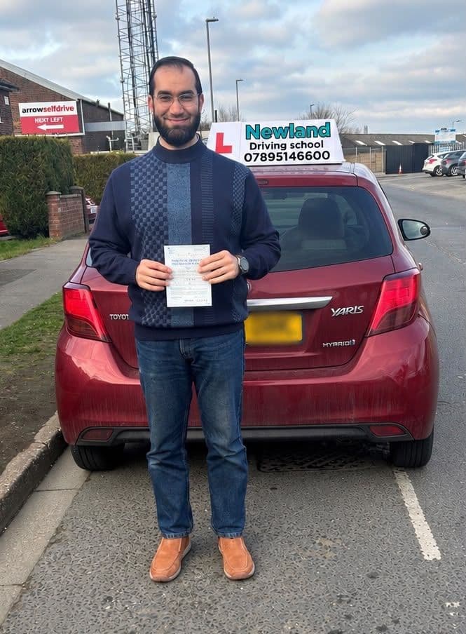 Pass photo 2: pupil with their pass certificate beside the red Toyota Yaris