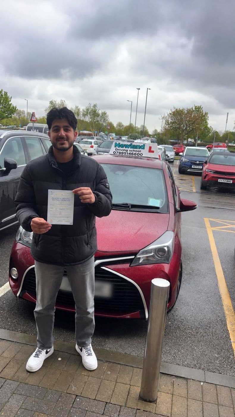 Pass photo 6: pupil with their pass certificate beside the red Toyota Yaris