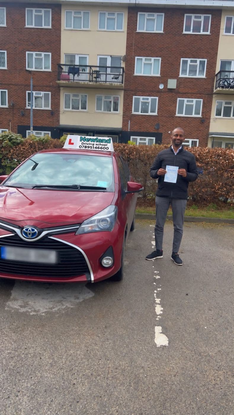 Pass photo 7: pupil with their pass certificate beside the red Toyota Yaris