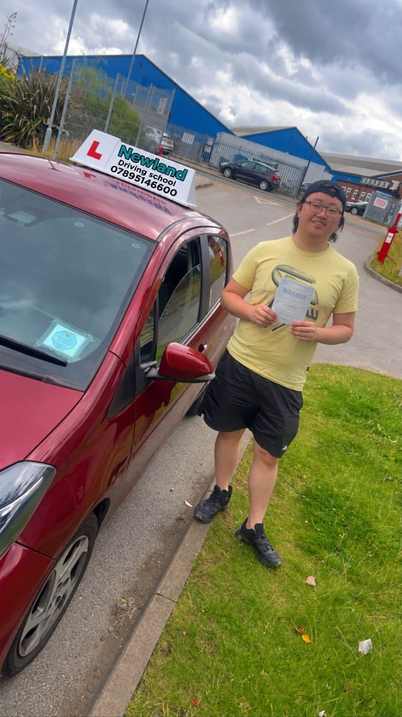Pass photo 11: pupil with their pass certificate beside the red Toyota Yaris