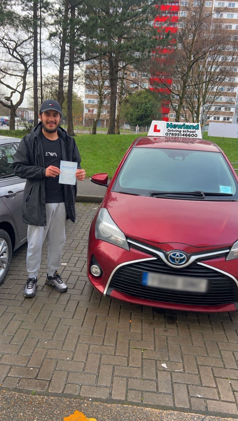 Pass photo 13: pupil with their pass certificate beside the red Toyota Yaris