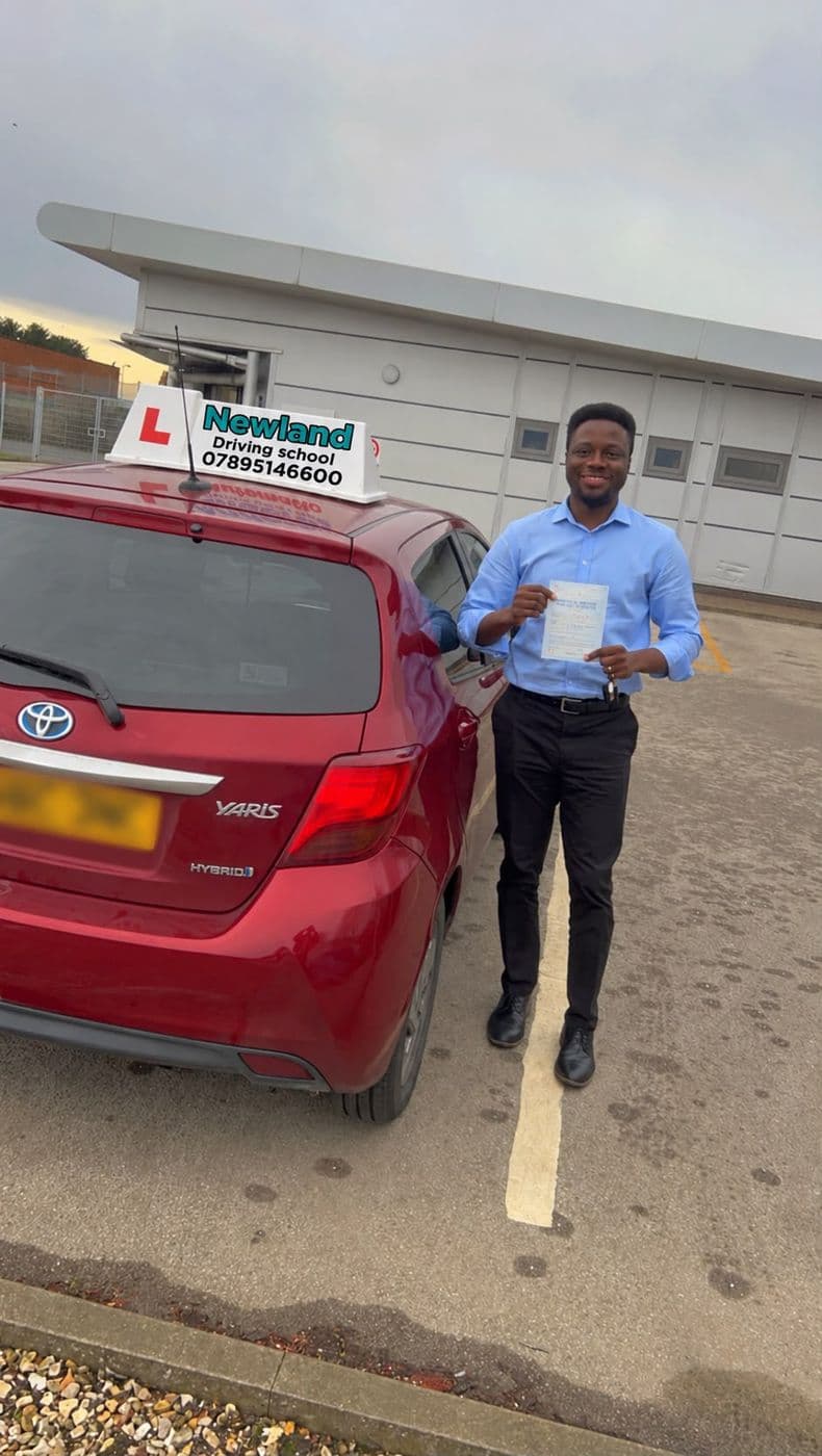 Pass photo 15: pupil with their pass certificate beside the red Toyota Yaris