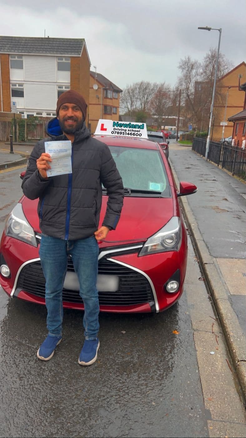 Pass photo 16: pupil with their pass certificate beside the red Toyota Yaris