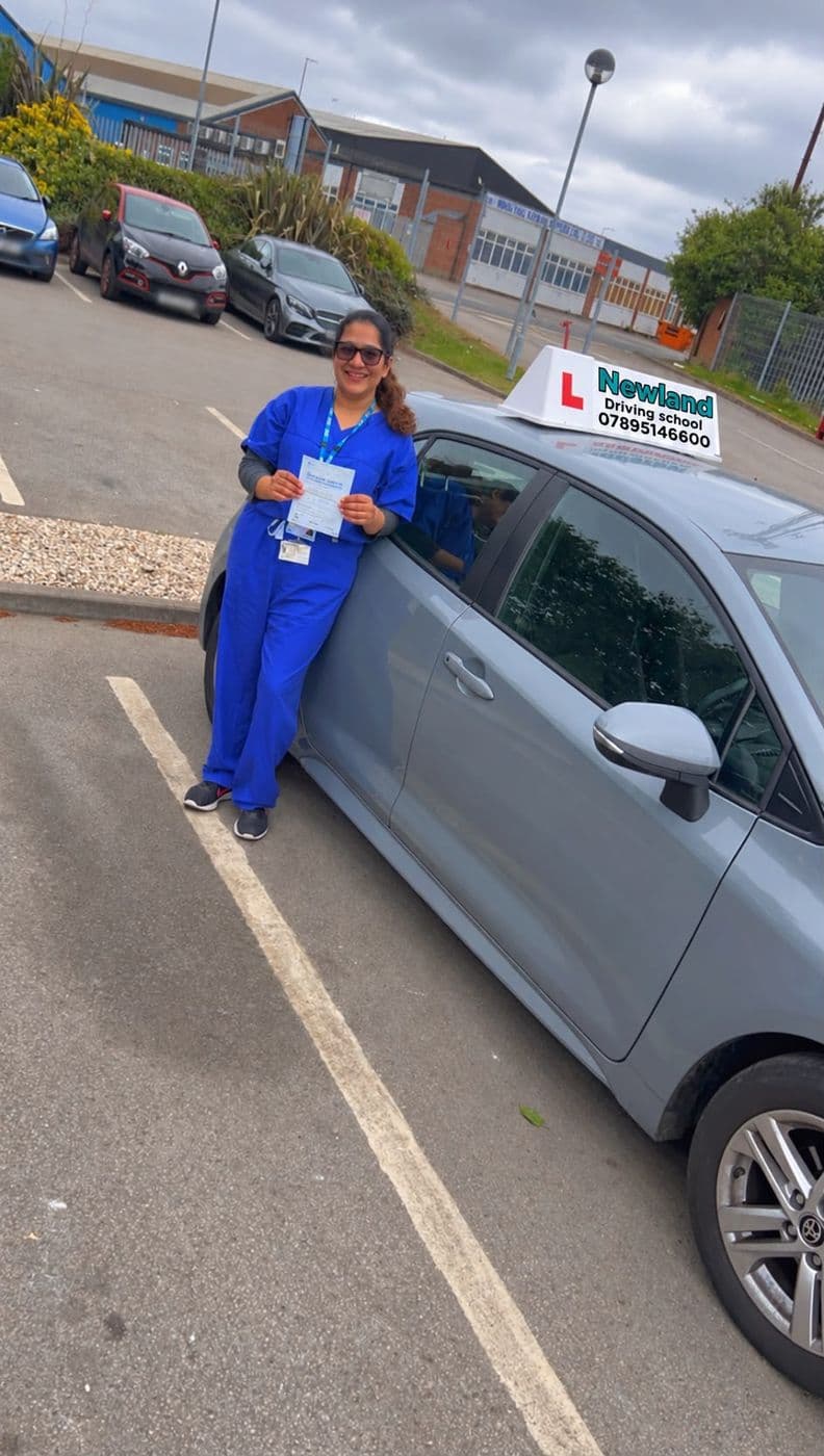 Pass photo 17: pupil with their pass certificate beside the silver Toyota