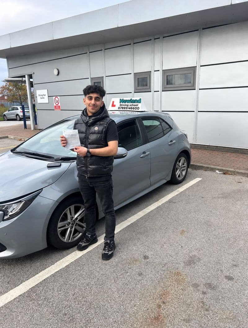 Pass photo 19: pupil with their pass certificate beside the silver Toyota