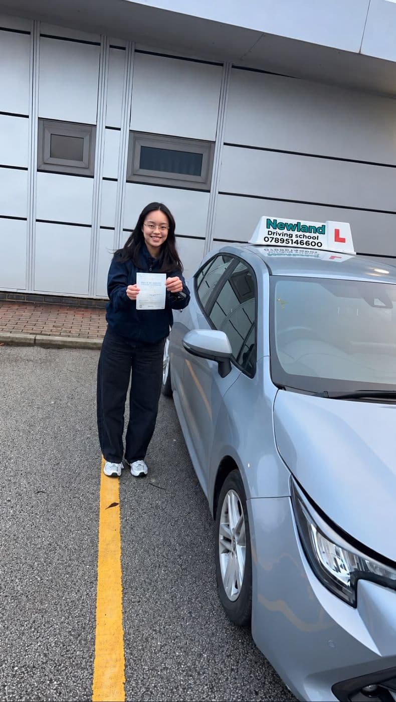 Pass photo 20: pupil with their pass certificate beside the silver Toyota