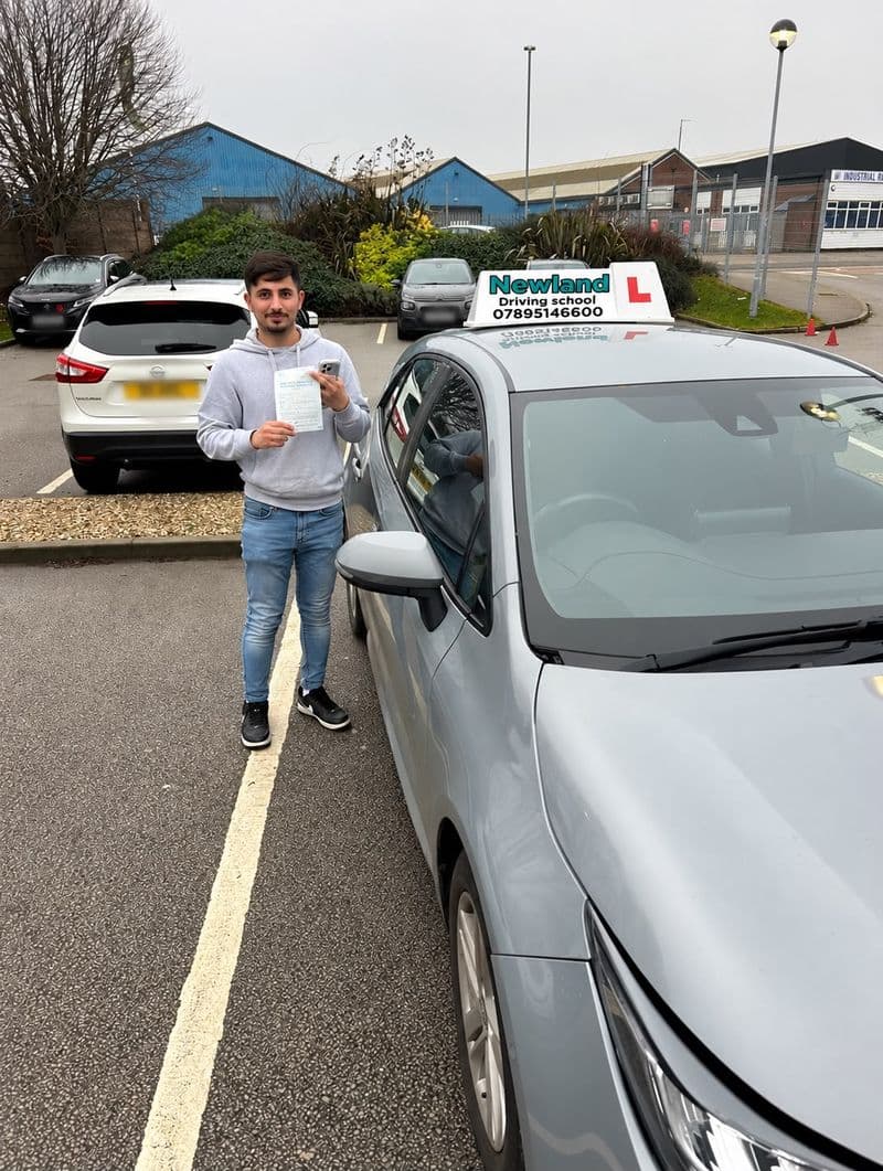 Pass photo 22: pupil with their pass certificate beside the silver Toyota