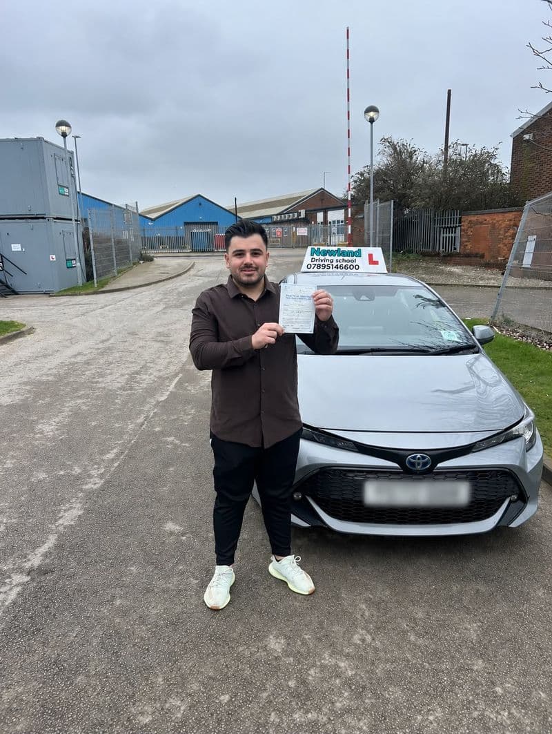 Pass photo 24: pupil with their pass certificate beside the silver Toyota