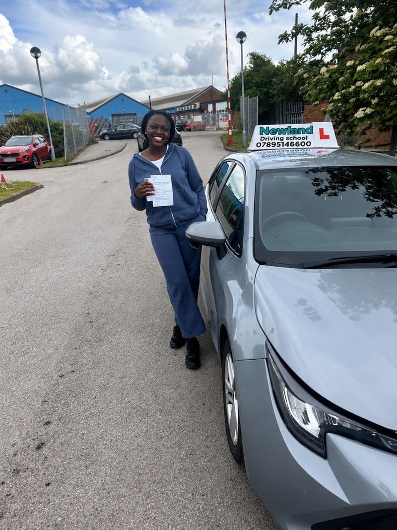 Pass photo 29: pupil with their pass certificate beside the silver Toyota