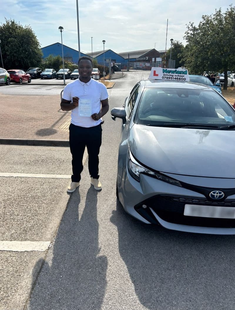 Pass photo 36: pupil with their pass certificate beside the silver Toyota