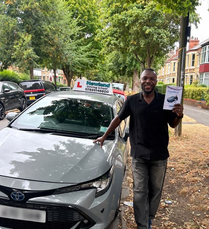 Pass photo 37: pupil with their pass certificate beside the silver Toyota