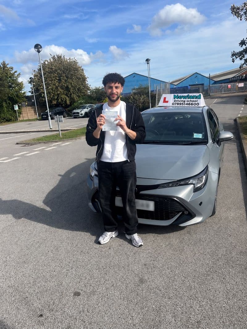 Pass photo 38: pupil with their pass certificate beside the silver Toyota