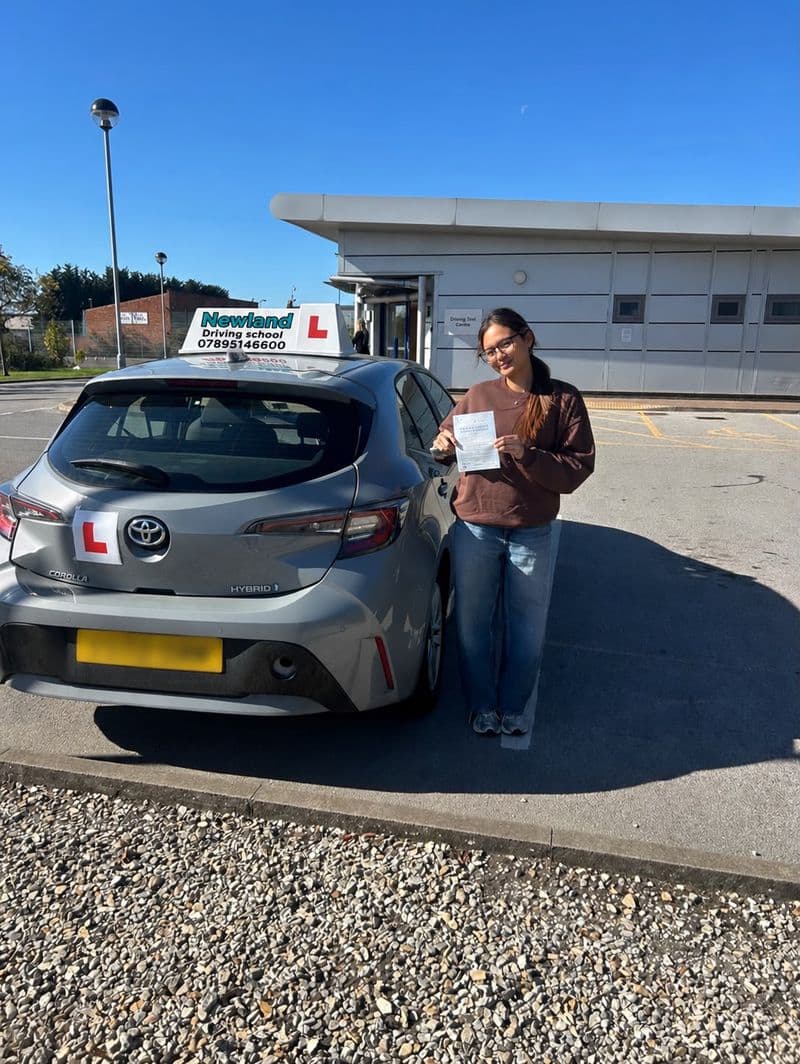 Pass photo 39: pupil with their pass certificate beside the silver Toyota