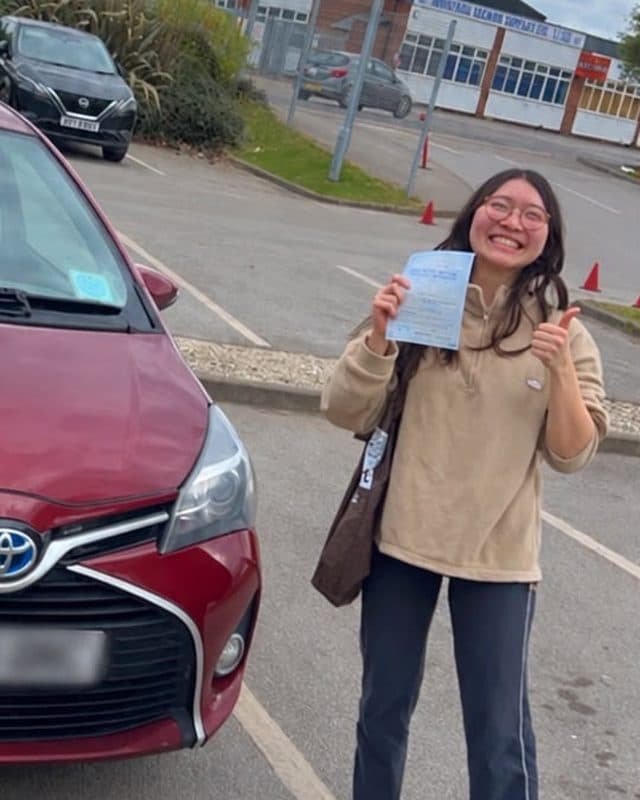 Pupil giving a thumbs up with her pass certificate